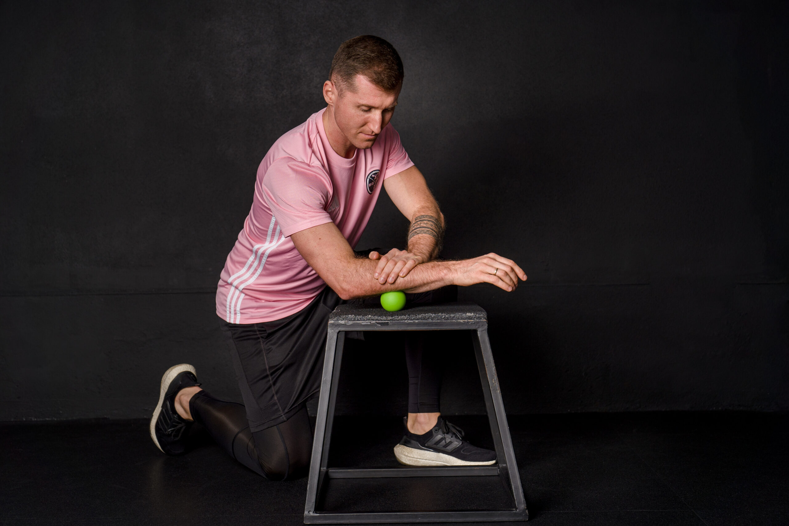 Meżczyzna pokazujące ćwiczenie rozciągajace z piłka